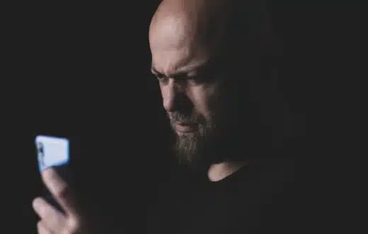 Ilustrasi pengguna smartphone sedang mencoba mengatasi layar HP freeze di rumah